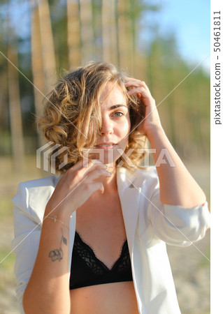 Caucasian girl with tattoo walking on sand beach and wearing white shirt. Caucasian girl with tattoo walking on sand beach and wearing white shirt. 50461811