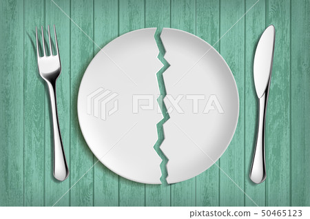 Broken white plate on a green wooden table. 50465123