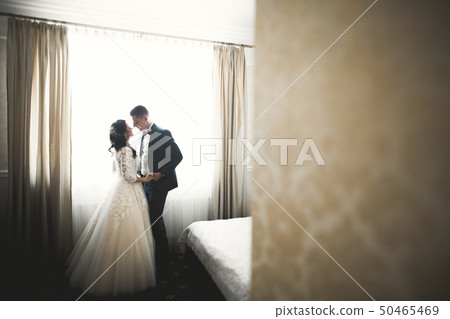 Cute happy bride and groom preparing for wedding Cute happy bride and groom preparing for wedding 50465469