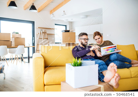 A young couple with color samples sitting on sofa, moving in new home. 50468541