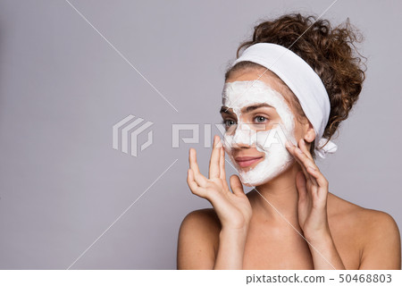 A portrait of a young woman with mask in a studio, beauty and skin care. A portrait of a young woman with mask in a studio, beauty and skin care. 50468803