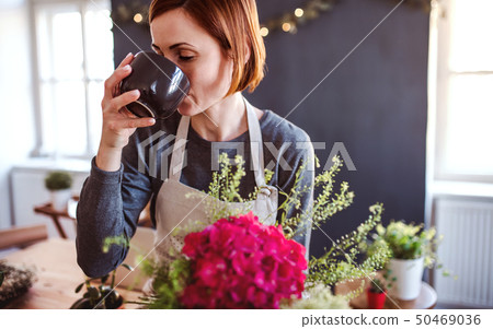 A young creative woman in a flower shop. A startup of florist business. A young creative woman in a flower shop. A startup of florist business. 50469036