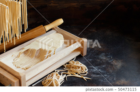 Making tagliolini pasta alla chitarra with a tool Making tagliolini pasta alla chitarra with a tool 50473115