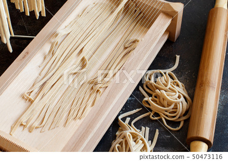 Making tagliolini pasta alla chitarra with a tool Making tagliolini pasta alla chitarra with a tool 50473116