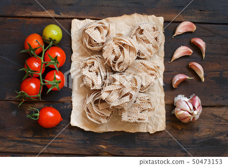 Whole wheat pasta tagliatelle, tomatoes and garlic 50473153