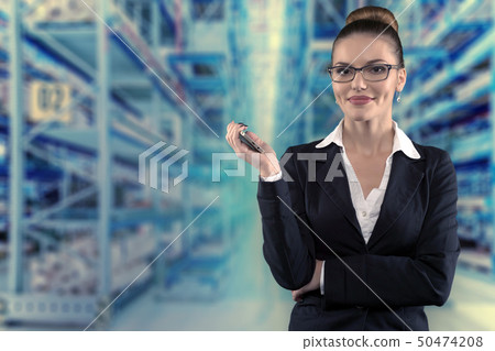 Beautiful serious business woman with glasses on futuristic empty warehouse Beautiful serious business woman with glasses on futuristic empty warehouse 50474208