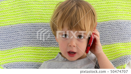 Little smiling child boy hand holding mobile phone Little smiling child boy hand holding mobile phone 50474707