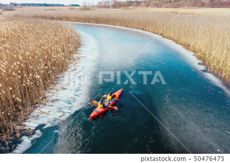 two athletic man floats on a red boat in river 50476475