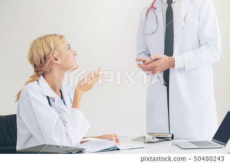 Female doctor at hospital talking to her partner. 50480243