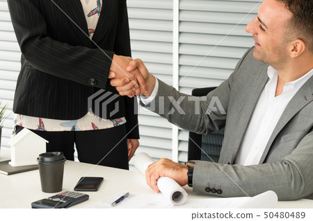 Businessman handshake businesswoman in office. Businessman handshake businesswoman in office. 50480489