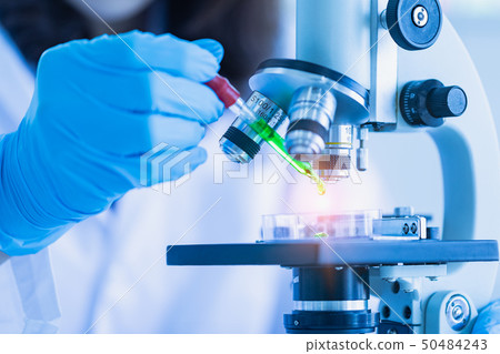 Scientist dropping liquid to petri dish.. 50484243