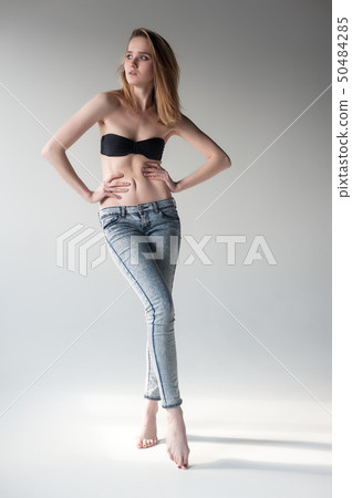 Attractive smiling woman in jeans and bra Attractive smiling woman in jeans and bra 50484285