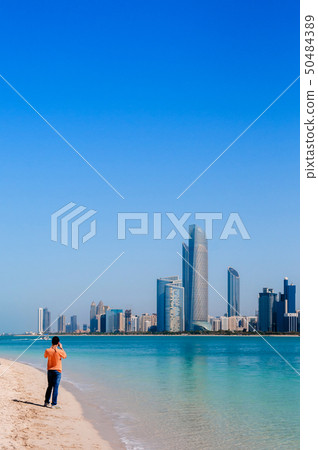 Tourists on beach at marina island with modern Abu Tourists on beach at marina island with modern Abu 50484389