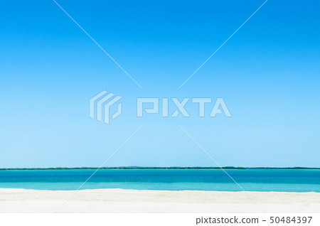 Blue sea white beach under bright sky at Yas 50484397