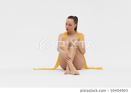 Naked young woman sitting on floor Naked young woman sitting on floor 50484903