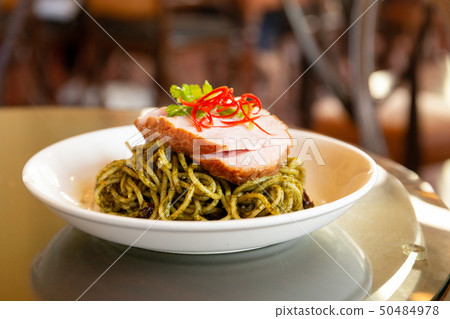 Spaghetti pasta with pesto sauce with sliced of ham on top. Spaghetti pasta with pesto sauce with sliced of ham on top. 50484978