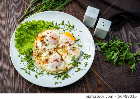 Flat lay of tasty breakfast over grey concrete table background. Fried eggs, micro greens, fresh 50489030