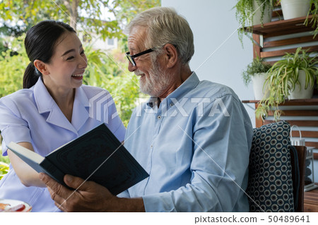 senior man happiness with smiling nurse, read book 50489641