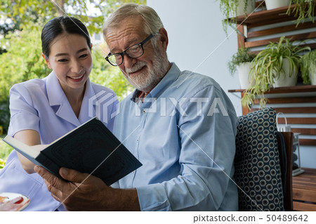 senior man happiness with smiling nurse, read book 50489642