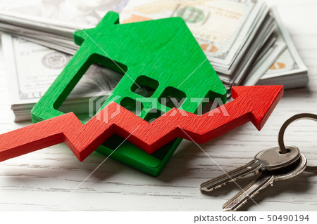 Up arrow and house with money on white wooden background. Market growth in real estate prices 50490194