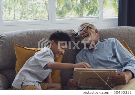 senior man happiness and grandson are sitting on 50490331