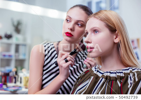 Pleasant blonde woman speaking with her visagiste 50492739