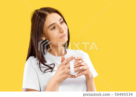 Portrait of beautiful woman isolated on yellow studio background 50493534