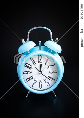 Blue alarm clock on black background Blue alarm clock on black background 50494166
