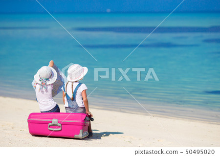 Little girls with big suitcase and map at tropical beach Little girls with big suitcase and map at tropical beach 50495020