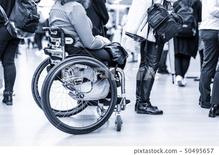 Close up of unrecognizable hanicapped woman on a wheelchair queuing in line to perform everyday 50495657