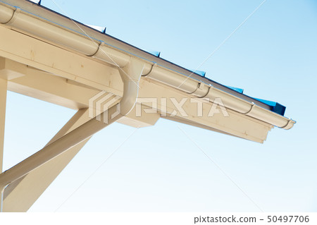 Gutter on house corner. Metal eave on roof 50497706