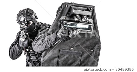 Studio shot of SWAT police special forces with pistol hiding