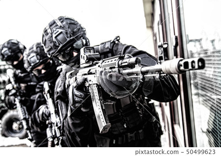 Police special reaction team member aims with gun Police special reaction team member aims with gun 50499623