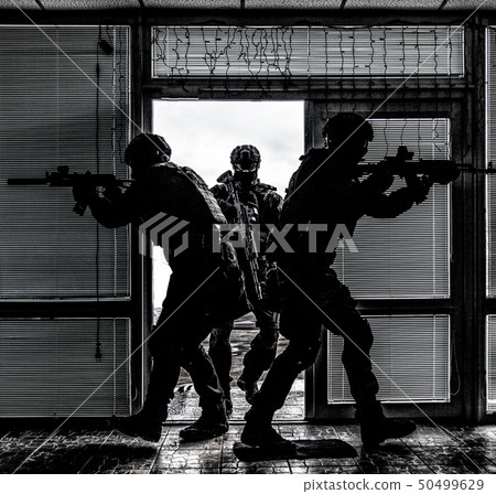 SWAT team breaching door and storming apartments SWAT team breaching door and storming apartments 50499629