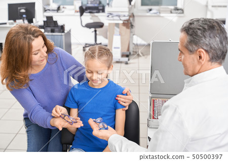Patient choosing glasses for eyesight correction. Patient choosing glasses for eyesight correction. 50500397