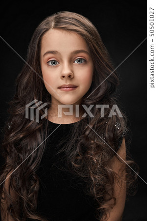 Pretty, little girl in black dress posing. 50501027