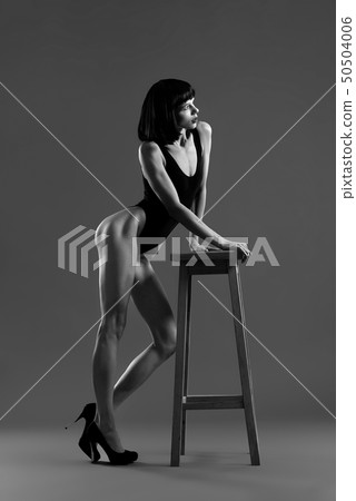Model with short black hair leaning on chair. 50504006