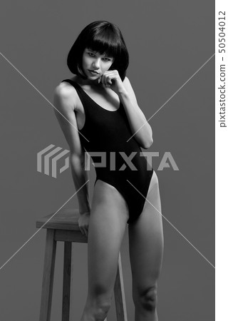 Beautiful brunette holding hand on chin, posing. Beautiful brunette holding hand on chin, posing. 50504012
