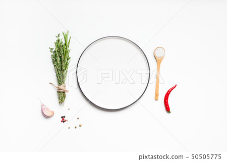 Empty plate with greens herbs and spices around Empty plate with greens herbs and spices around 50505775