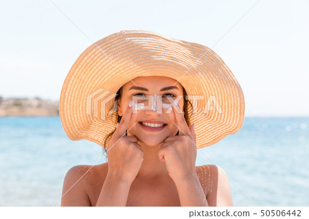 Sun shaped sunscreen on woman 50506442