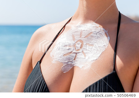 Sun shaped sunscreen on woman Sun shaped sunscreen on woman 50506469