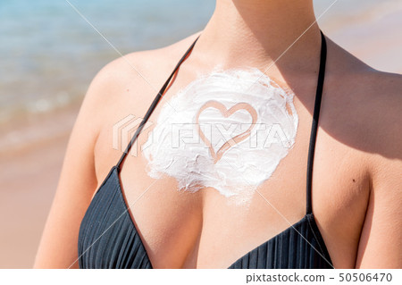 Sun shaped sunscreen on woman Sun shaped sunscreen on woman 50506470