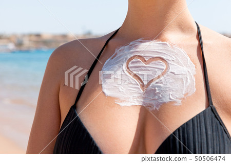 Sun shaped sunscreen on woman Sun shaped sunscreen on woman 50506474