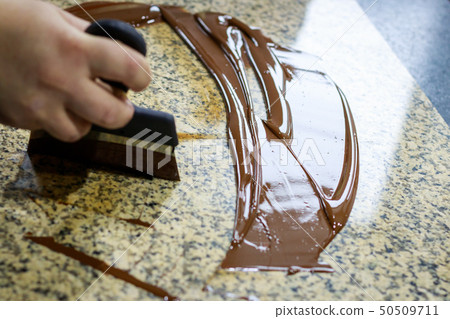Liquid tempered chocolate applied in a thin layer Liquid tempered chocolate applied in a thin layer 50509711