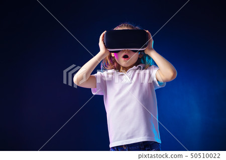 Girl 7 y.o. experiencing VR headset game on colorful background. Surprised emotions on her face Girl 7 y.o. experiencing VR headset game on colorful background. Surprised emotions on her face 50510022