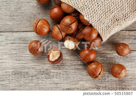 Macadamia nut on a wooden table in a bag, closeup, 50515807