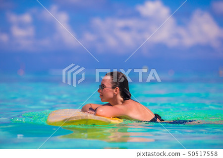 Beautiful fitness surfer woman surfing during summer vacation Beautiful fitness surfer woman surfing during summer vacation 50517558