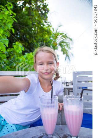 Little girls taking selfie and drinking tasty cocktails at tropical resort Little girls taking selfie and drinking tasty cocktails at tropical resort 50517843