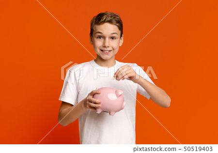 Little boy putting pocket money in piggy bank Little boy putting pocket money in piggy bank 50519403
