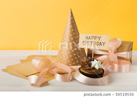 Delicious cupcake and gift on yellow background 50519550